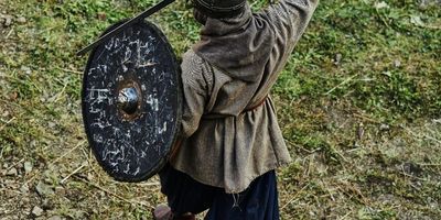 man in medieval garb holding a sword and shield