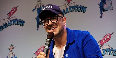 Steve Burns smiling and holding a microphone