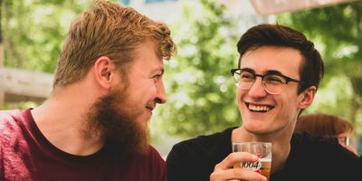 two men talking, drinking beer