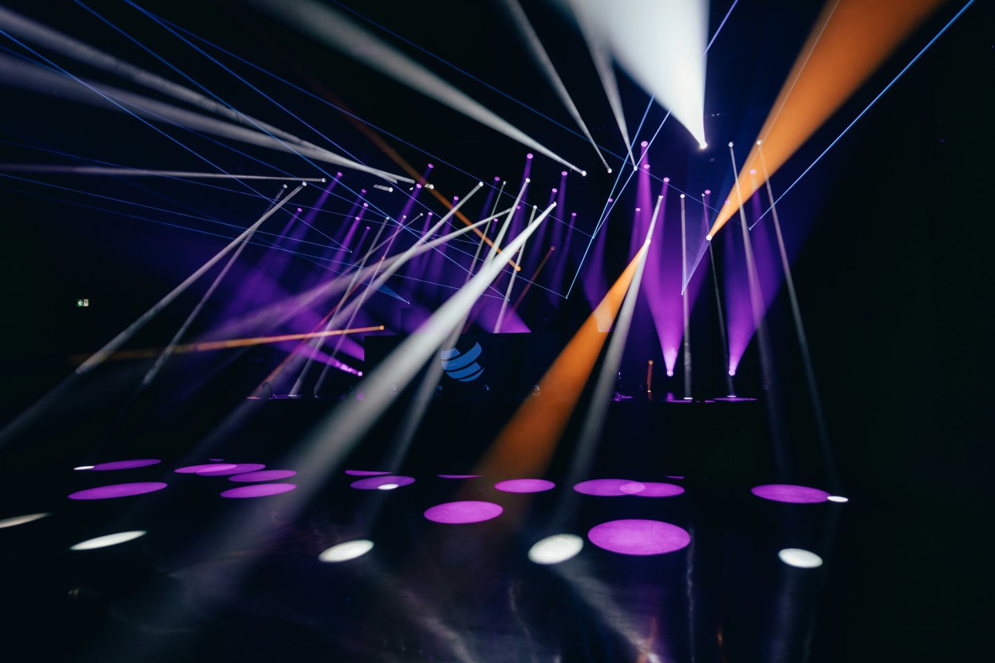 Colorful stage lights and laser beams in a dark room.
