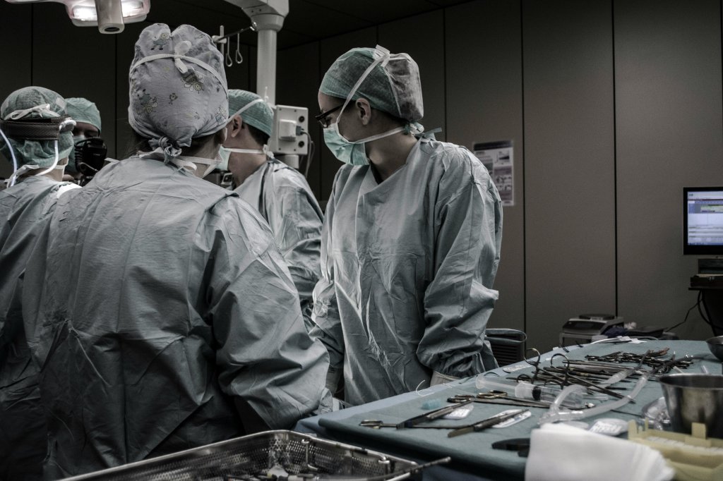 Surgical team in the operating room with tools laid out on a table.