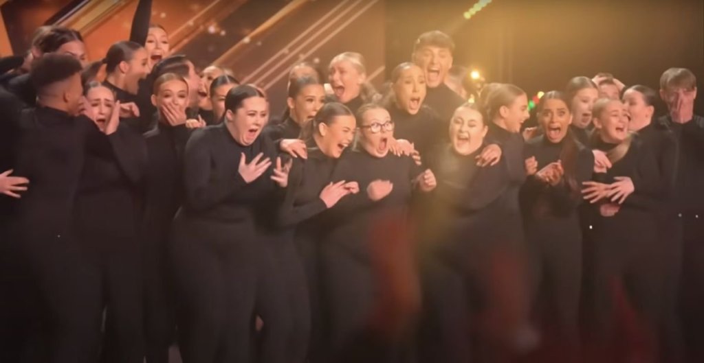 Dancers dressed all in black celebrating on stage