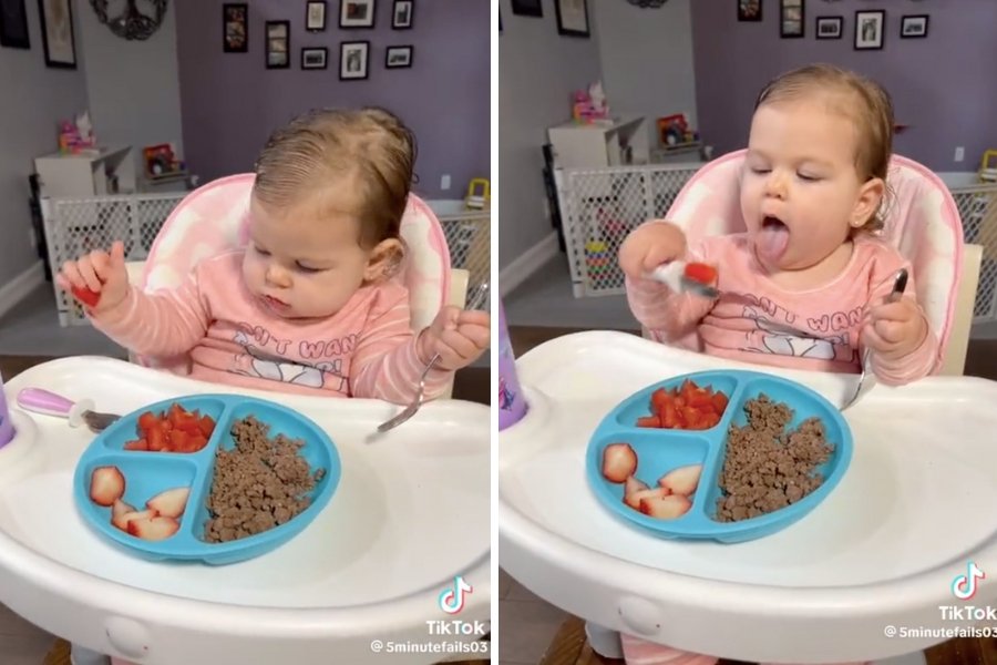 baby in a highchair eating with a spoon and fork