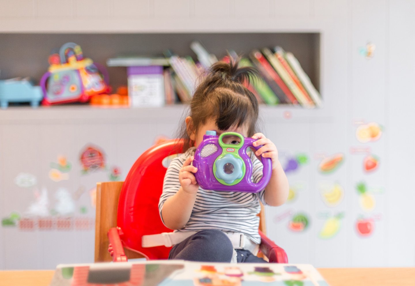 toddler holding a toy camera