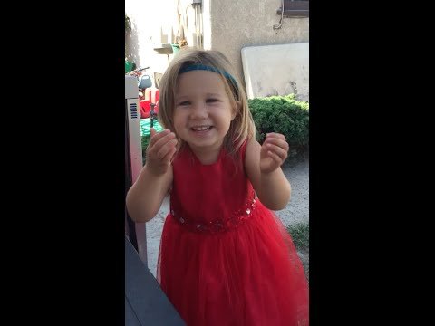 little girl in a red dress gesturing with her hands