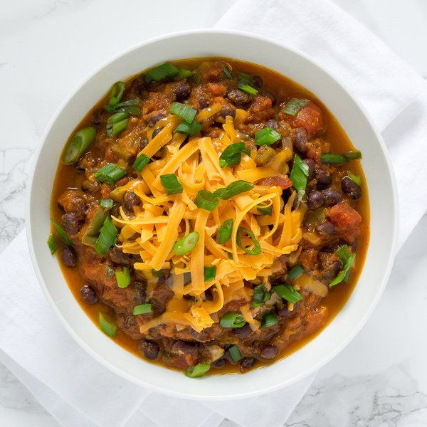 bowl of chili with cheese and green onions on top