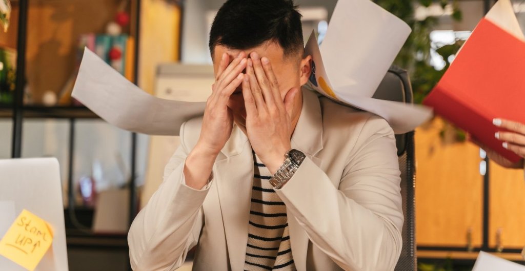 man in an office with his head in his hands