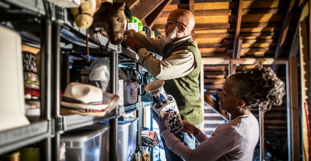 man and woman in an attic full of stuff