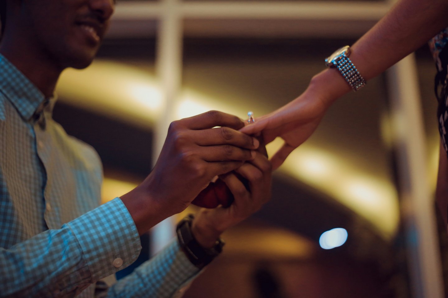 man putting an engagement ring on a woman