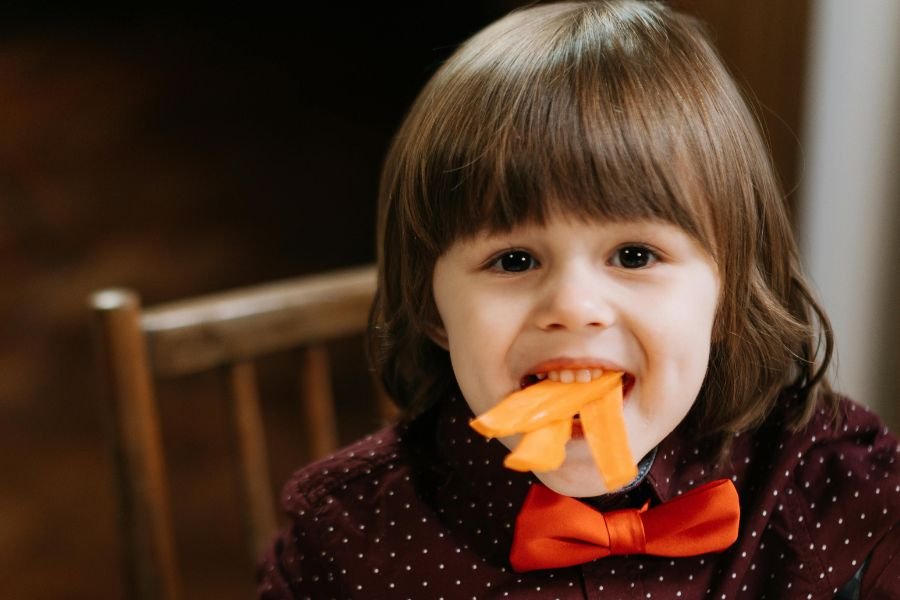 kid with carrots hanging out of his mouth