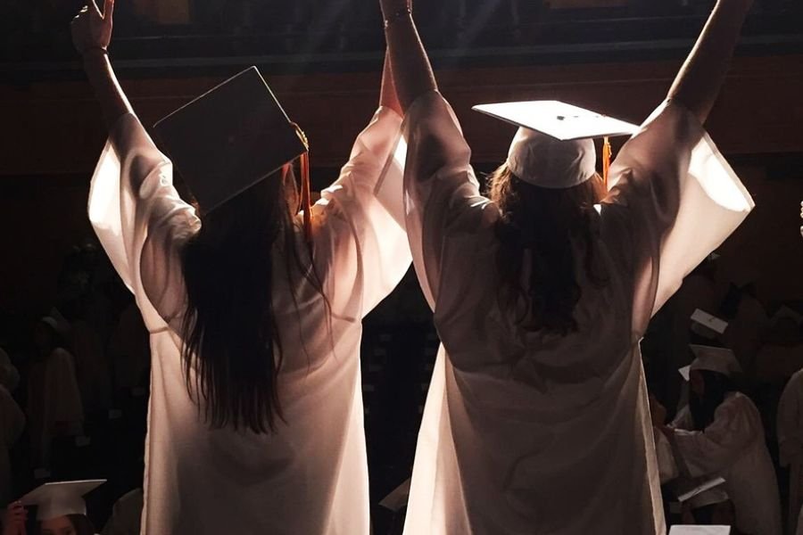 two graduates in cap and gown