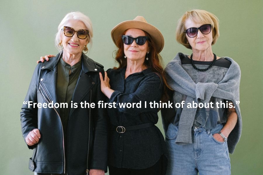 Three older, stylish women facing the camera and smiling