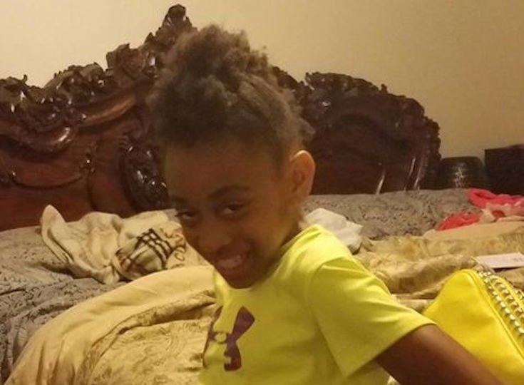 A girl in yellow shirt smiling at the camera