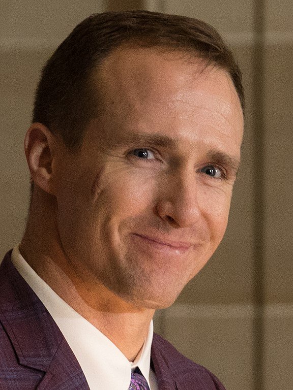 Drew Brees wearing a suit and smiling
