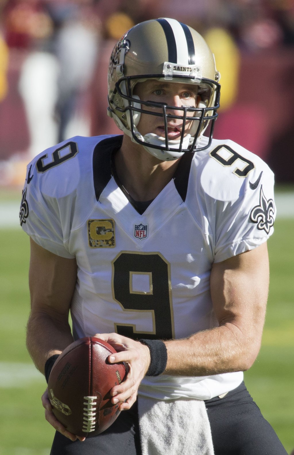 Drew Brees holds a football in his New Orleans Saints uniform