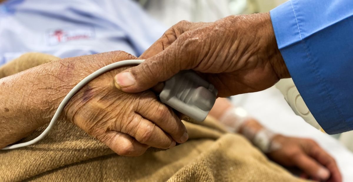 man holding an old woman's hand in hospital