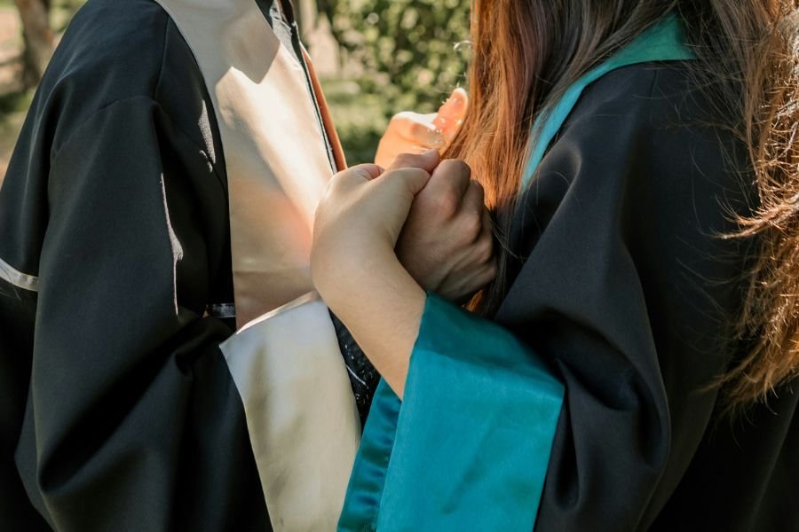 two graduates holding hands