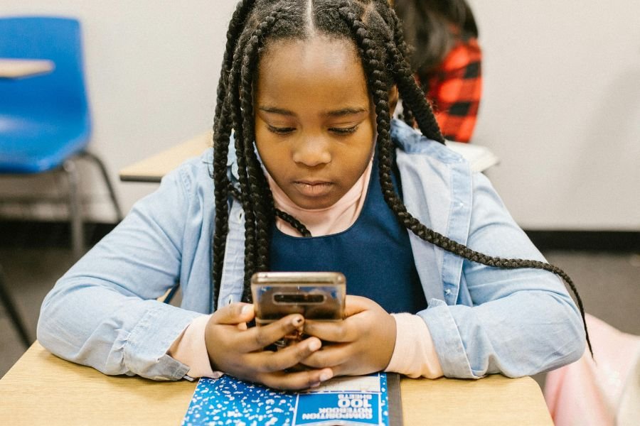 girl sitting at desk on cell phone