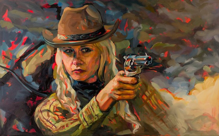 Woman in cowboy hat pointing pistol