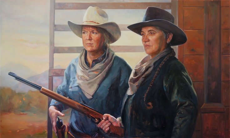 Two women in cowboy hats and Western gear holding a rifle