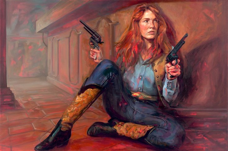 Woman sitting in cowboy boots holding two pistols
