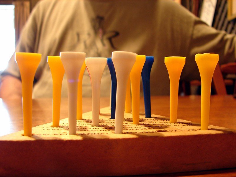 Yellow and blue pegs in a wooden pyramid board