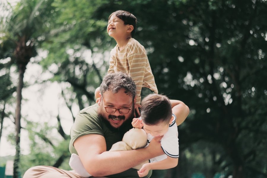 man playing with two small children