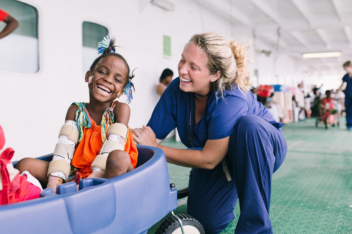 A young girl recoving from a procedure with her nurse.