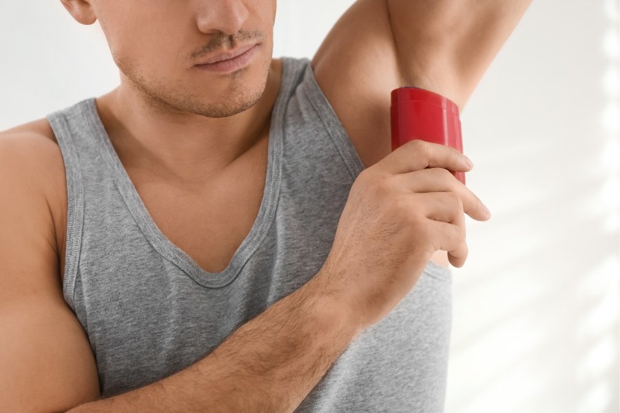 man putting on deodorant