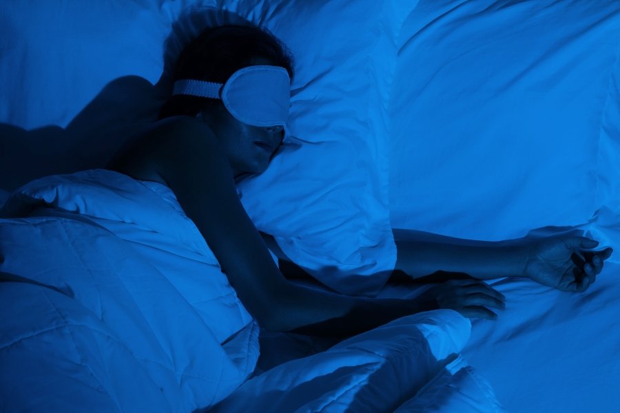 woman wearing sleep mask in bed