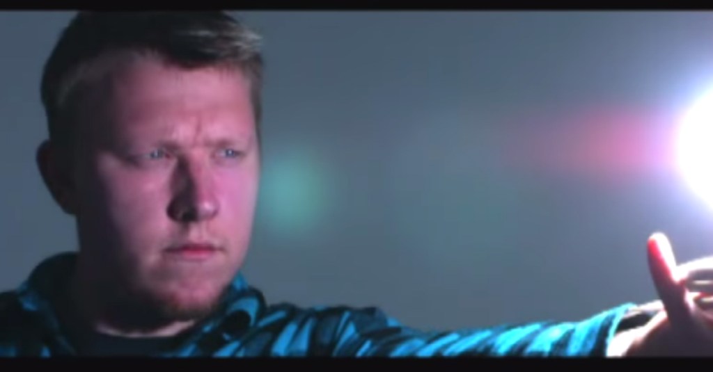 a man holds out his arm toward a ball of light