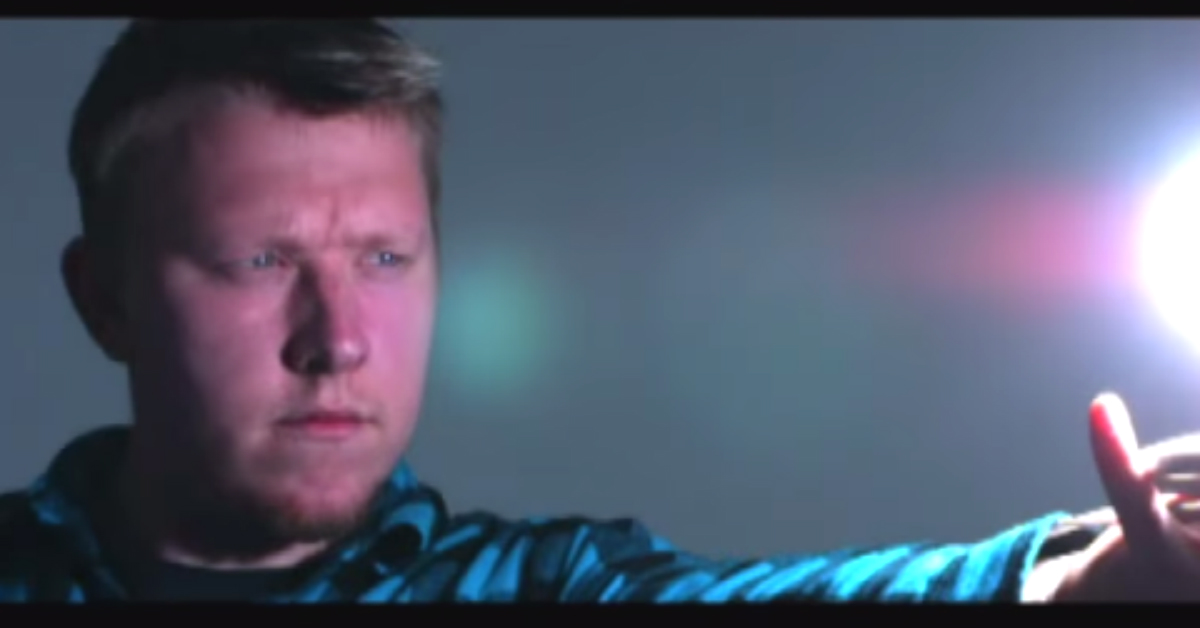 a man holds out his arm toward a ball of light