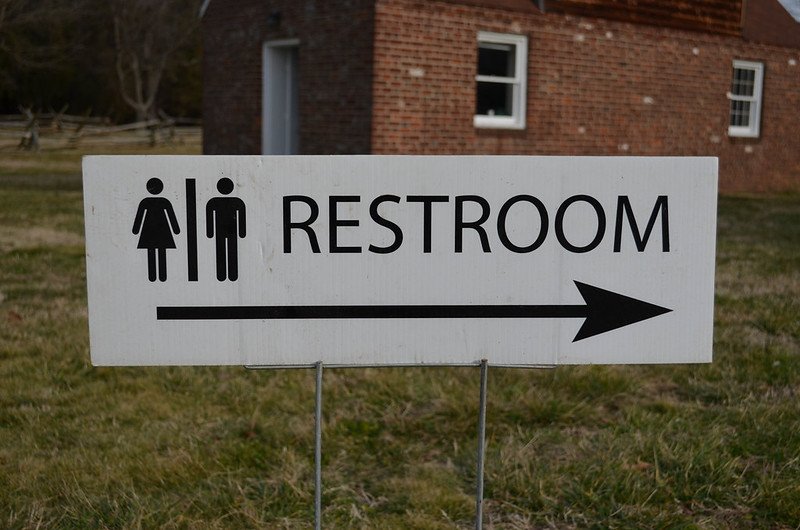 A male and female restroom sign with arrow pointing to the right