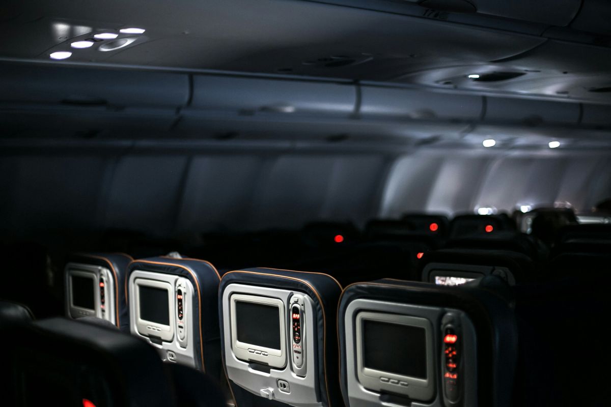 interior of an airplane with seats and movie screens
