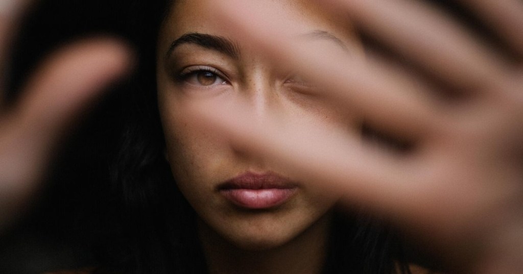 blurred hands obscuring woman's face