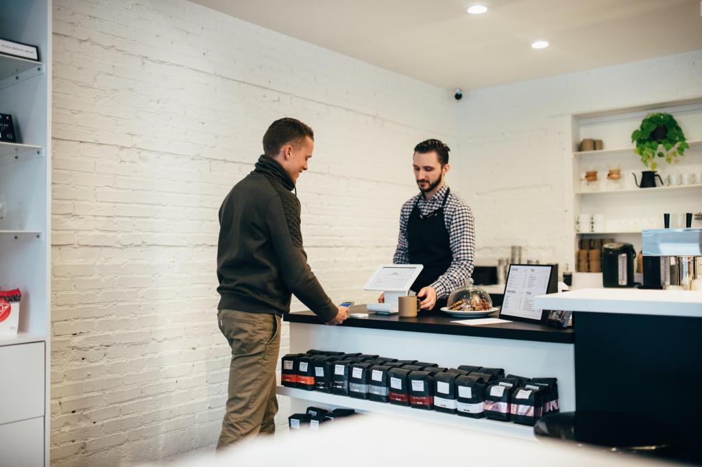 two men on either side of a counter completing a purchase