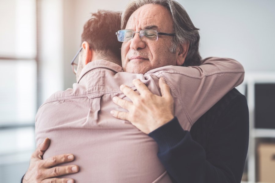 older man hugging younger man