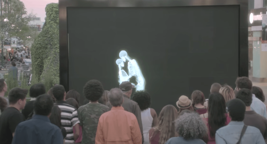 crowd watching embracing skeletons through screen