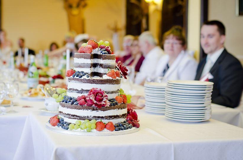 wedding cake surrounded by guests