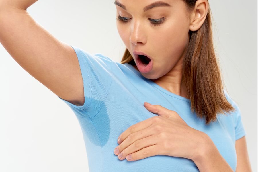 surprised woman looks at armpit stain