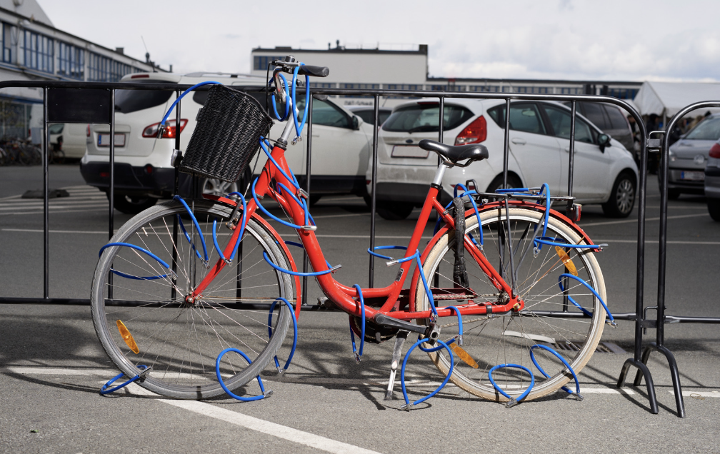 A bike with multiple bike locks on a gate