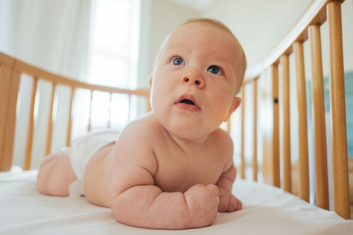 baby with diaper inside crib