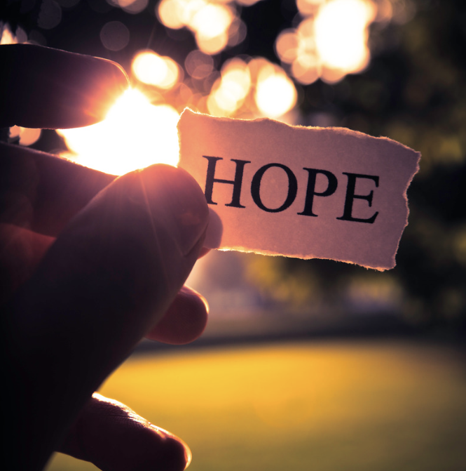 A hand holding a note that says 