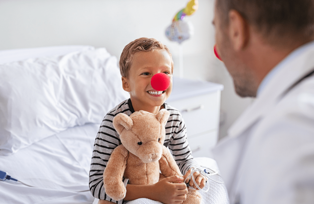 Doctor and child patient wearing clown noses