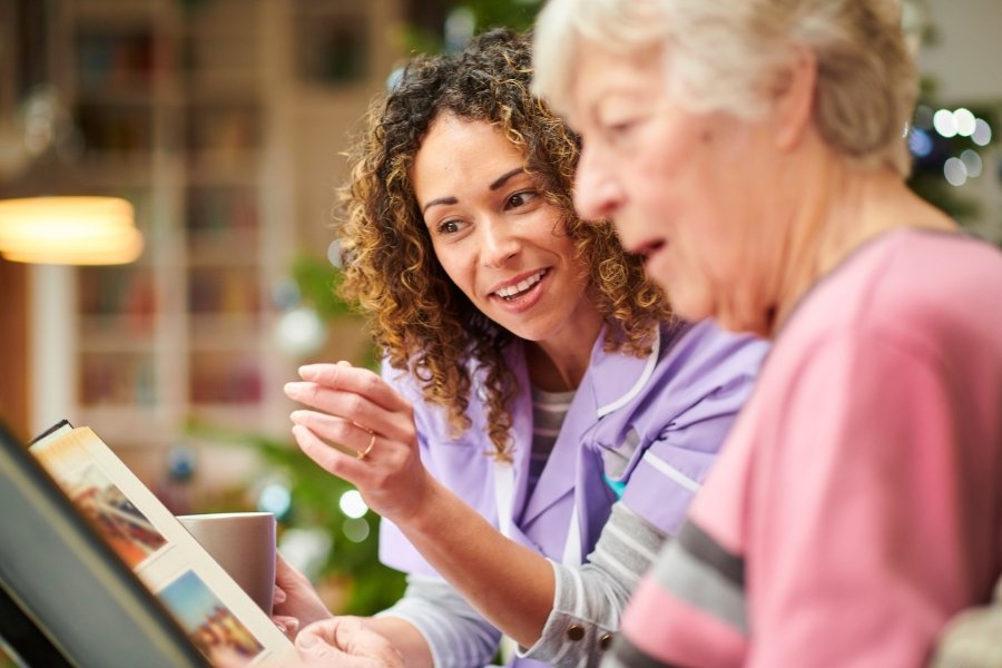 younger woman looking at a book with an older woman