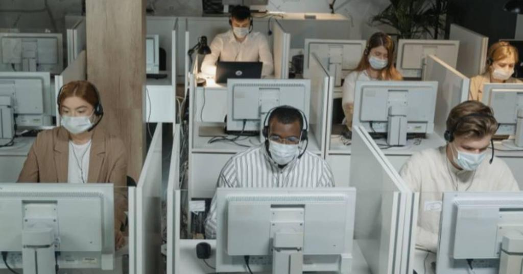 people in masks working at computers
