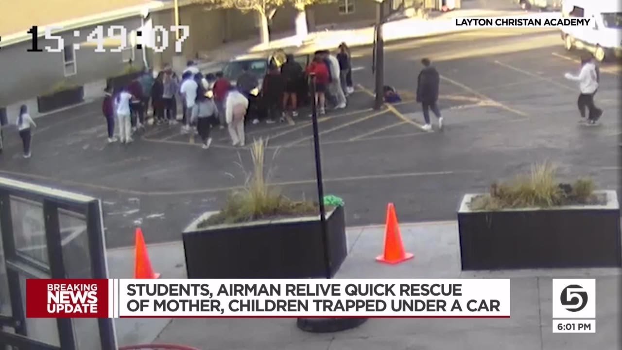 group of teens lifting car in parking lot