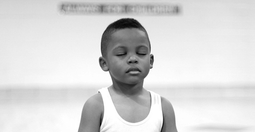 Young Black boy stands with eyes closed