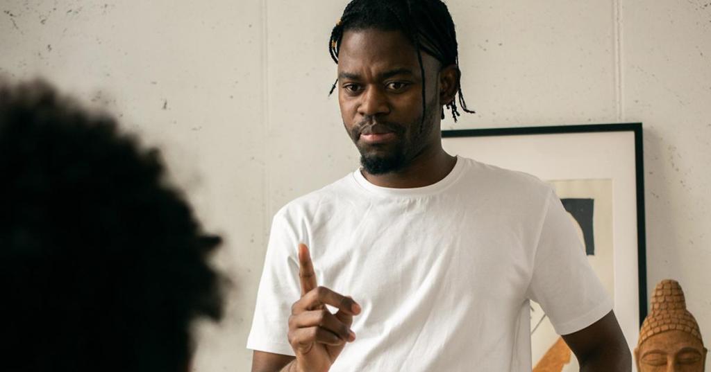 father in white shirt shakes finger at child in reprimand