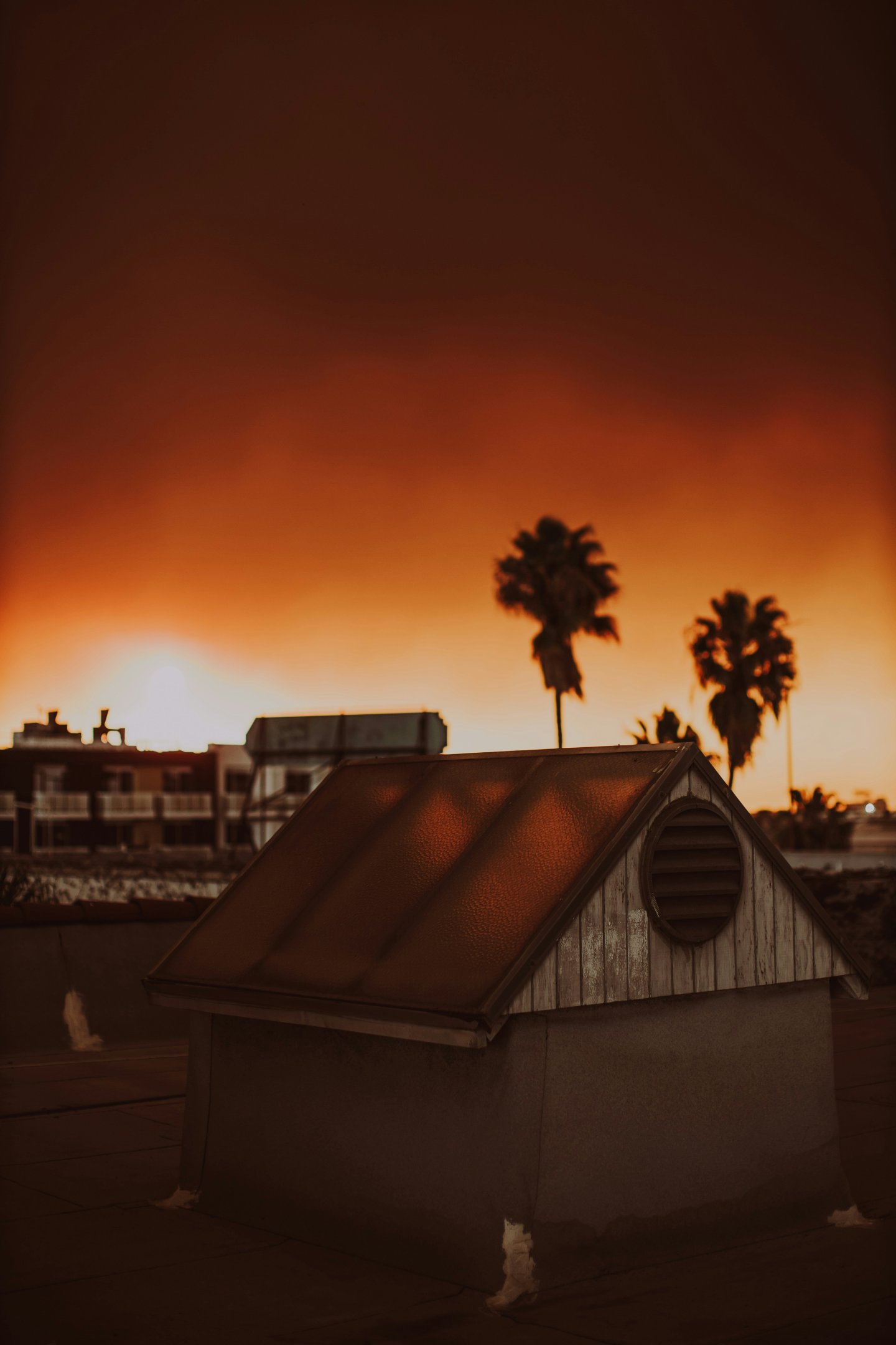A picture of a house with a red sky in the background